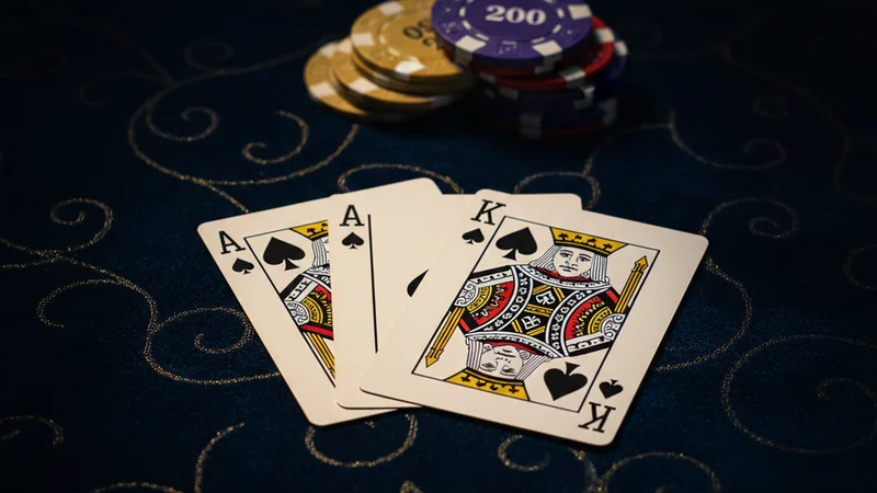 Ace and King of Spades on dark navy velvet tabletop